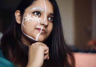 young-woman-with-face-paint-looking-away-sitting-home